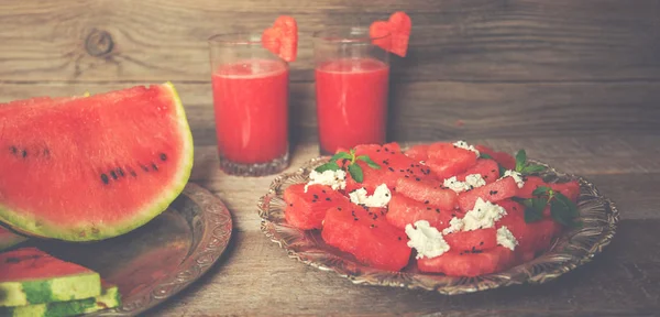 Fresh summer watermelon salad with feta cheese, arugula, onions on rustic background.