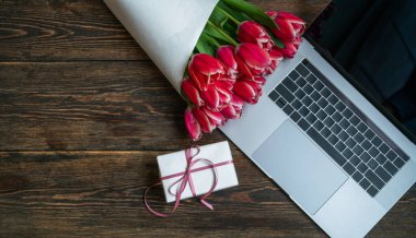 Anneler günü, sevgililer günü, kadınlar günü, bahar tatilleri mevsimsel satış, alışveriş, aşk, özel teklif, indirim. Eski ahşap arka planda dizüstü bilgisayar, hediye ve laleler, alışveriş afişi şablonu.