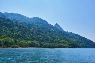 Beyaz kum ve mavi gökyüzü turkuvaz suyu ve granit kayaları ile tropik cennet plajı turizm arka planında seyahat eder. Malezya 'daki Tioman adasının cennet plajlarında inanılmaz tropikal tatiller.