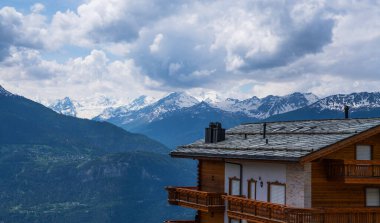 Alp köyünün panoramik manzarası. Güzel eski ahşap ev ve arka planda Alp dağları karla kaplıydı. İsviçre, Avrupa.