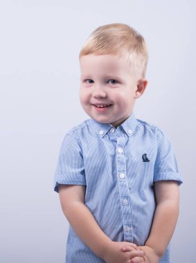 Mavi gömlek gülümseyen çocuk mutlu