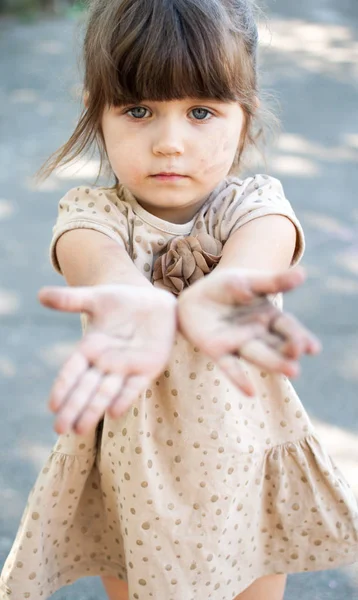 Söt liten flicka med smutsiga händer titta på kameran — Stockfoto