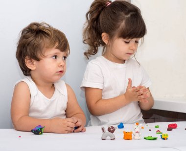 Having oyunculuk ile birlikte bir günlük bakım, renkli modelleme kil iki sevimli küçük çocuklar. Yaratıcı çocuklar evde kalıp. Erkek ve kız hamuru veya hamur ile oynamak.