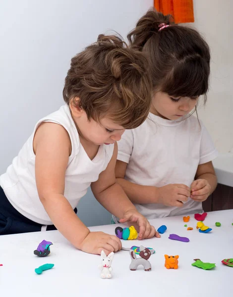 Çocuk çamurdan sculpts. Sevimli küçük kız ve erkek kalıplar üzerinden hamuru oda tablo. Çocukların yaratıcılık ve eğitim kavramı.