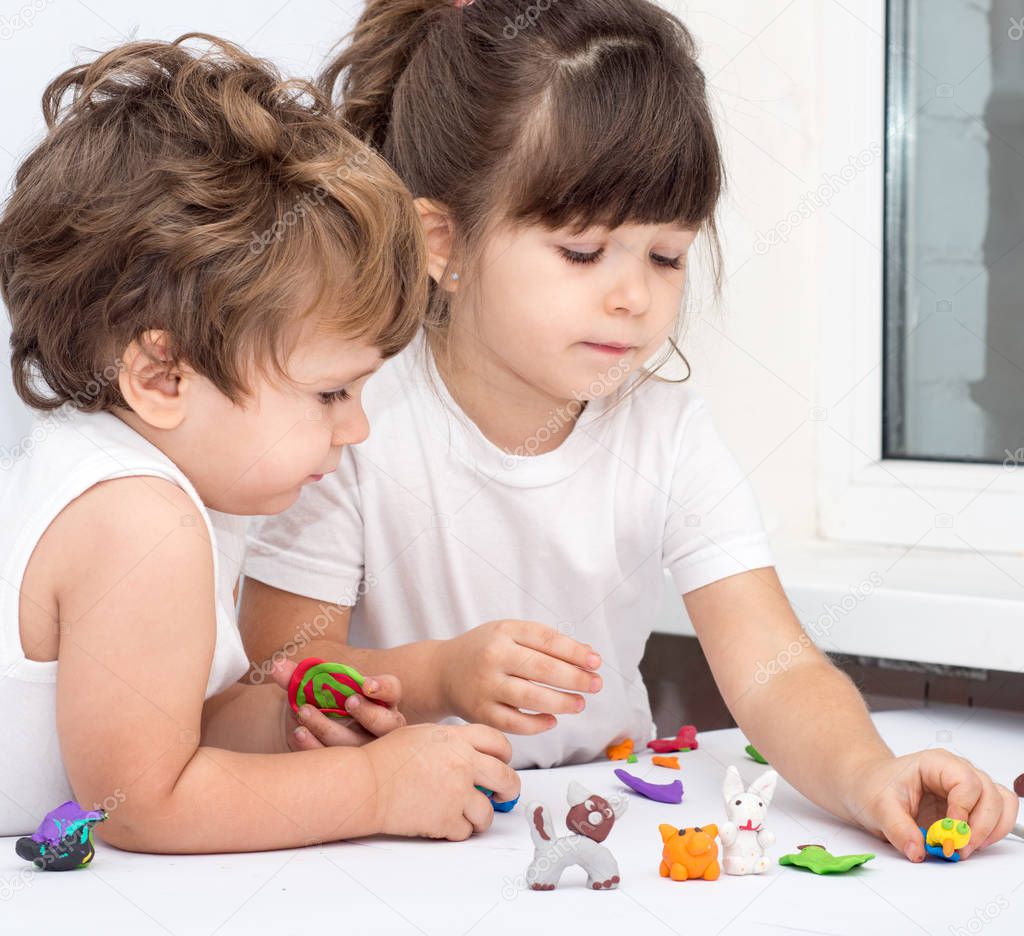 Children playing with plasticine. Development toys for preschooler kids