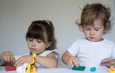 Çocuklar renkli modelleme kil ile oynuyor. Küçük evde kalıp çocuk. Okul öncesi çocuklar için geliştirme oyuncaklar