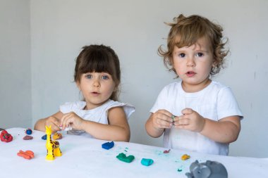 Çocuklar renkli modelleme kil ile oynuyor. Küçük evde kalıp çocuk. Okul öncesi çocuklar için geliştirme oyuncaklar