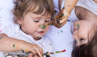 Beyaz arka plan üzerinde izole renkli boya boyalı ellerle komik çocuk