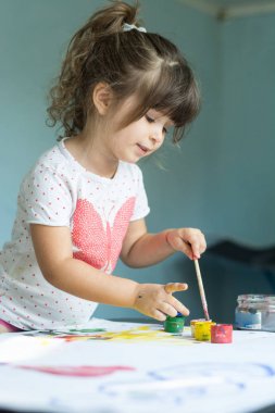 Güzel bir çocuk çiziyor. Boya Fırçası ve suluboya ile güzel küçük kız.