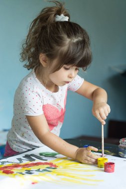 Güzel bir çocuk çiziyor. Boya Fırçası ve suluboya ile güzel küçük kız.