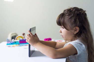 Küçük kız evde Tablet Pc kullanarak ya da anaokulu. Eğitim, bilim, teknoloji, çocuk ve insan kavramı