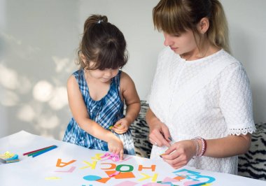 Güzel kadın İngilizce alfabe tanımak için kızı öğretim