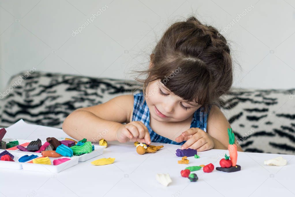 Child playing with colorful modeling clay at kindergarten. Little kid molding clay plasticine at home. Development toys for preschooler children