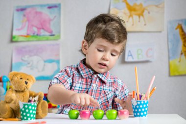Elma okulda matematik dersinde sayma sayıları hakkında öğrenme küçük bir çocuk. Mutlu 2 ya da 3 yaşındaki çocuk, anaokulu iç arka plan.
