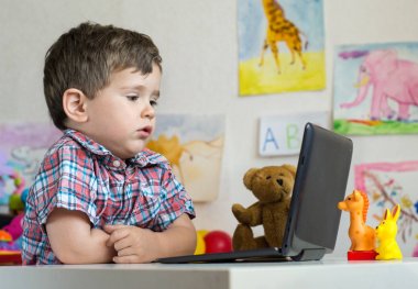 Küçük çocuk evde defter ya da anaokulu kullanarak. Eğitim, bilim, teknoloji, çocuk ve insan kavramı