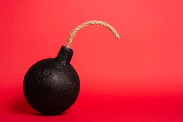 Foto Uma Bomba Redonda Com Fusível Aceso Sobre Fundo Vermelho — Fotografia de Stock