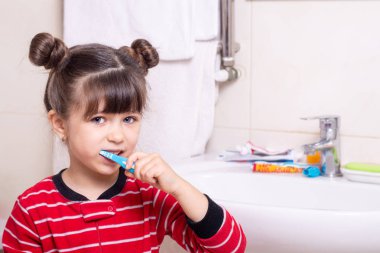 Banyoda dişlerini fırçalayan küçük bir çocuk. Çocuk diş fırçası.