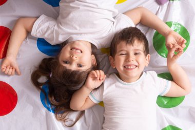 Evde oynayan iki beyaz erkek ve kız kardeş var. Kardeş sevgisi. Dostluk kavramı.