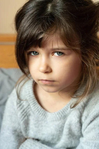 Little child with puzzled look.  Small child  with curly brown-haired, big blue eyes 6 or 5 years old. Whats wrong.