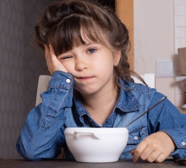 Çocuk yemeyi reddediyor. Anne çocuğunu sağlıklı sebze çorbasıyla besliyor. Çocuk sağlıklı besleniyor.