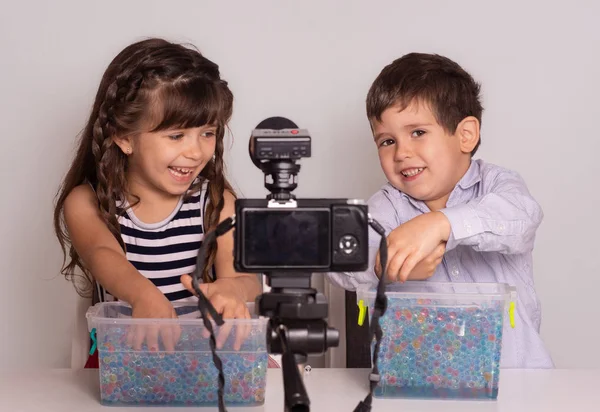 Cute little video bloggers recording video on white background. Kids video blog concept.