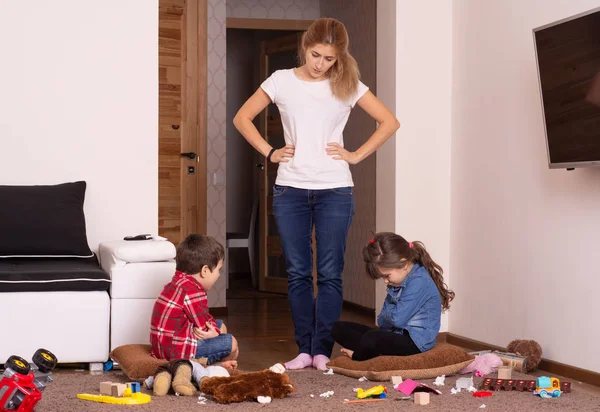 Woman scolds children. Mess in the house.