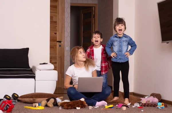 Evde dizüstü bilgisayarla çalışan meşgul bir anne. Mutsuz Çocuk. Dikkat eksikliği.