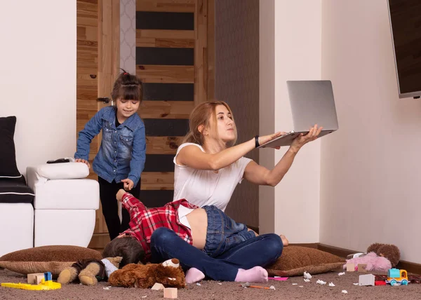 Evde dizüstü bilgisayarla çalışan meşgul bir anne. Mutsuz Çocuk. Dikkat eksikliği.