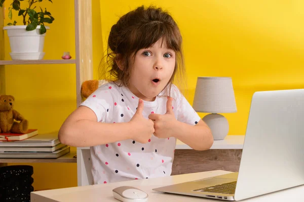 Havalı online okul. Çocuk evde tablet kullanarak online çalışıyor. Çevrimiçi e-öğrenme sisteminde çalışırken dizüstü bilgisayar kullanan neşeli küçük bir kız. Uzaktan öğrenme