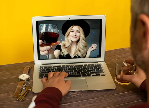 Online party. Young woman meeting virtual party and drink wine online together with her friend in video conference with laptop for a online meeting in video call for social distancing
