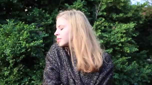 Prachtige blond meisje die zich voordeed op groene achtergrond — Stockvideo