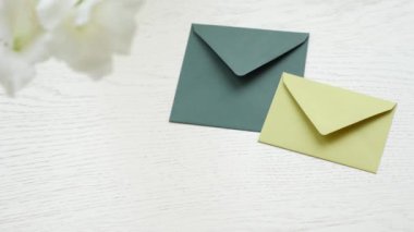 Çiçek giy kadın el ahşap masa arka plan üzerinde zarf