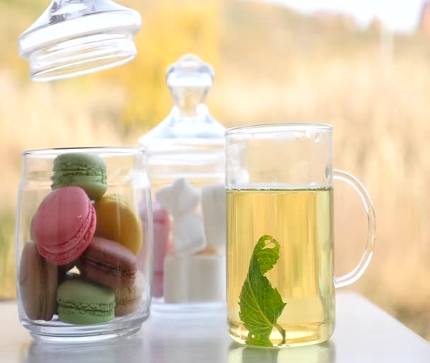 Чашка м'ятного чаю з макарунами та зефіром — стокове відео