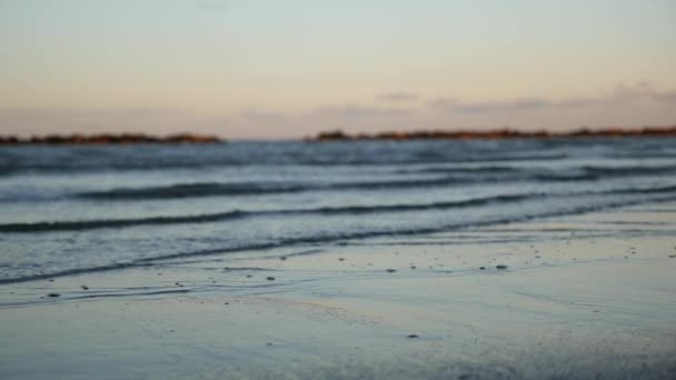 Морські хвилі на піску під час заходу сонця — стокове відео