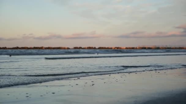 Olas marinas en la arena durante la puesta del sol — Vídeos de Stock