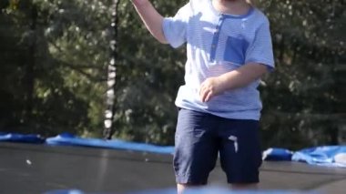 Ağır çekim bir şirin küçük çocuğun bir trambolin üzerinde atlama