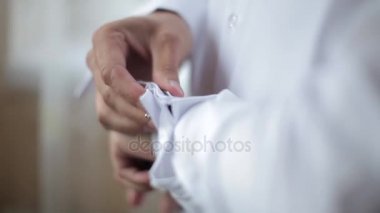 Dostum giyen papyon kollu beyaz gömleğinin kol düğmeleri koyar