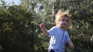 İlk kez atlama ve having fun açık kahverengi gözlü mutlu küçük sarışın çocuğun
