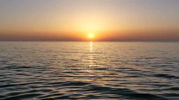 Puesta de sol en la playa. Colores del amanecer reflejados en el agua . — Vídeos de Stock