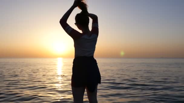 Blonde girl looking at the sunset and raising her arms, freedom concept. — Stock Video