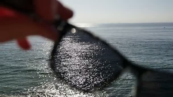 Regardez la belle mer et la plage du coucher du soleil à travers des lunettes de soleil — Video