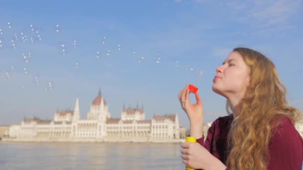 Attractive young woman blowing bubble in the Budapest — Stock Video