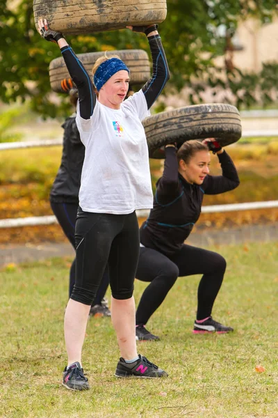 Girls squat with the tire. — Stock Photo, Image