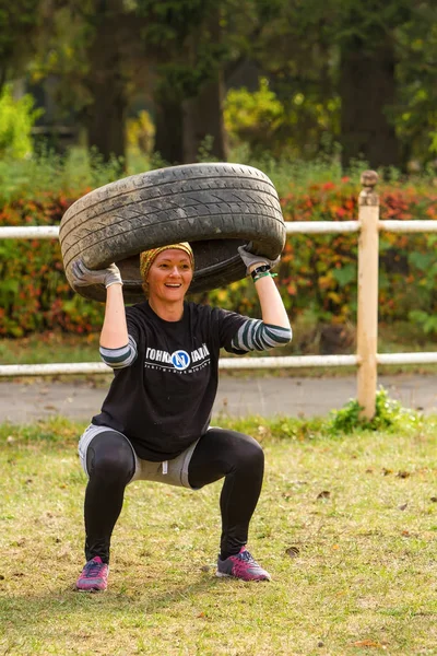 Girl squat with the tire. — Stock Photo, Image