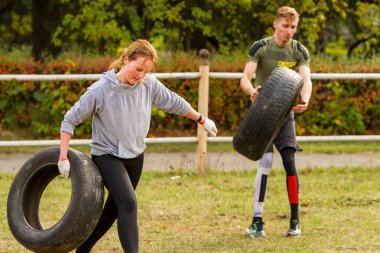 Adam ve kız bir lastik ile egzersiz.