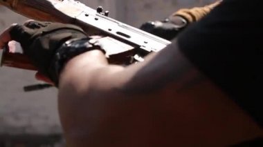 Ukrayna, Kyiv - 6 Nisan 2016. Miğferli siyahi adam bir şarjörü Kalaşnikof 'a yerleştirir, panjuru yerleştirir, nişan alır ve ateş eder. Hd