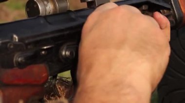 Ukrayna, Kiev - 8 Nisan 2016. Atış poligonu, maskeli keskin nişancı kıyafetli bir adam Degtyarev 'in keskin nişancı tüfeğiyle çalışmak için eğitilir, başarılı olamadığında eğitmen ona yardım eder. HD, ses yok..