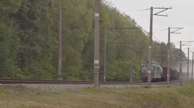Yük treninin hareketi, yoldan geçen bir tren havada çok fazla toz bırakır. Kamera trenin sağdan sola hareketini izler. Uzak çekim, Full HD,