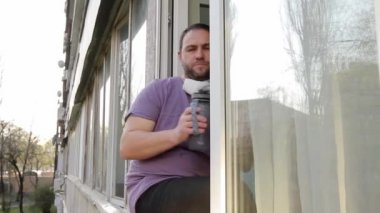 Boynuna maske takmış bir adam pencere kenarına oturur, spor şişesinden su içer, yüzüne maske takar ve gider. Kamera soldan sağa hareket ediyor. Tam HD, ses yok.