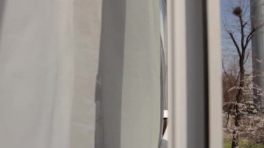 Adam pencereyi açar, derin bir nefes alır ve şiddetle öksürmeye başlar, pencereyi bırakır ve kapatır. Pencere çerçevesinde kamera hareketi, evden sokağa, soldan sağa.